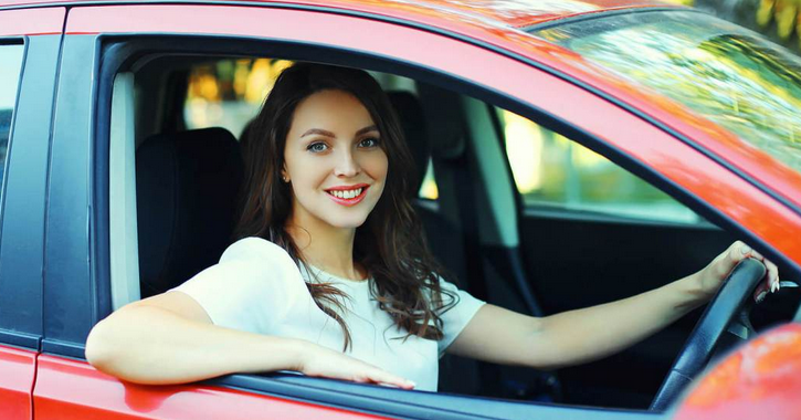 Gambar ini menunjukkan seorang pengemudi wanita dengan mobil merah