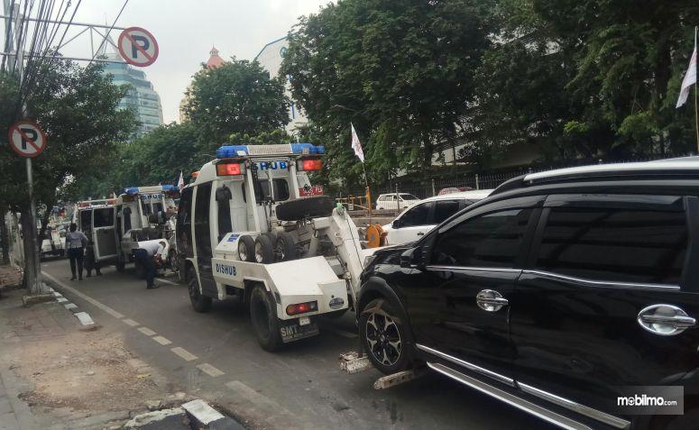 Gambar yang menunjukan kendaraan yang diangkut polisi karena parkir liar