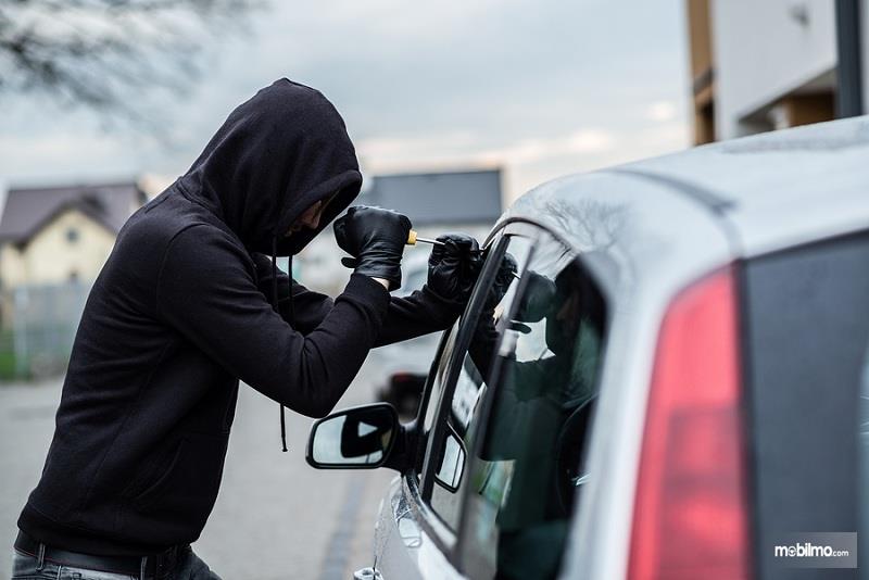 Gambar yang menunjukan pencuri yang sedang mencuri mobil