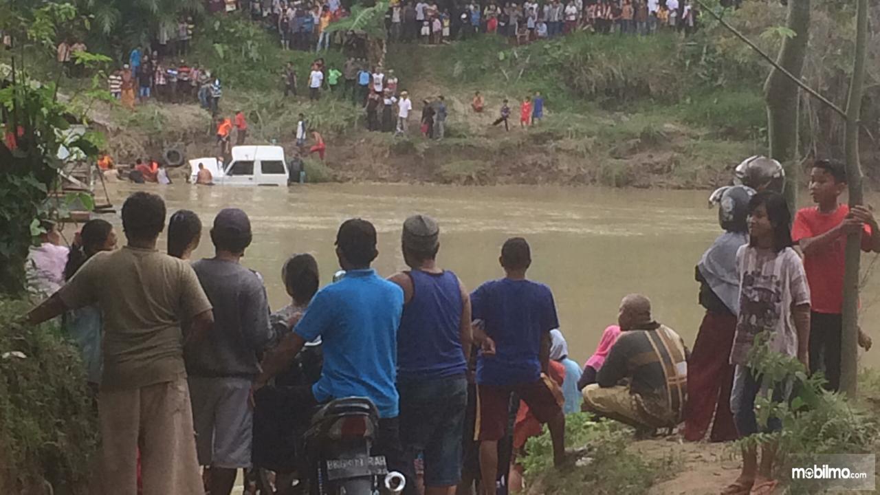 Warga menonton proses evekuasi Daihatsu Taft yang tenggelam di Langkat Sumatera Utara