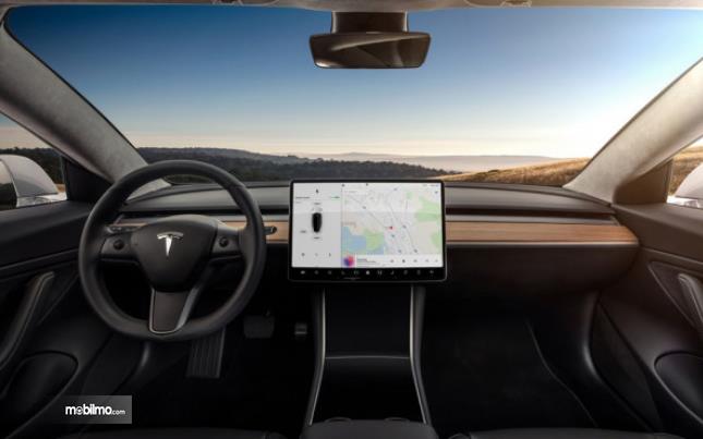 Gambar ini menunjukkan interior mobil dengan terlihat kemudi mobil dan layar besar pada dashboard