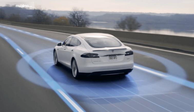 Gambar ini menunjukkan Mobil Tesla warna putih dengan ilustrasi lingkaran dan garis warna biru
