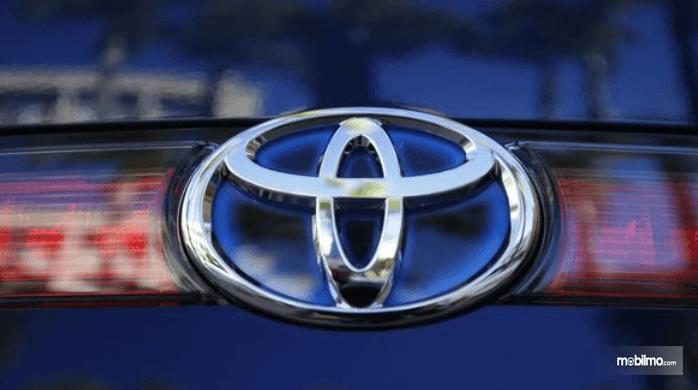 Gambar ini menunjukkan logo Toyota pada mobil warna biru