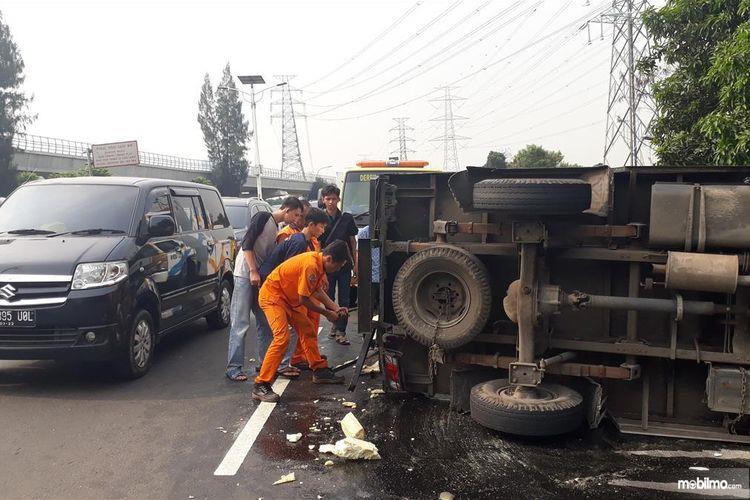 Foto menunjukkan satu unit truk pengangkut tisu dan minyak terguling di Jalan Tol Jagorawi