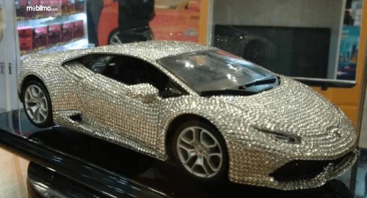 Gambar ini menunjukkan mobil Lamborghini Huracan mainan yang berbalut berlian