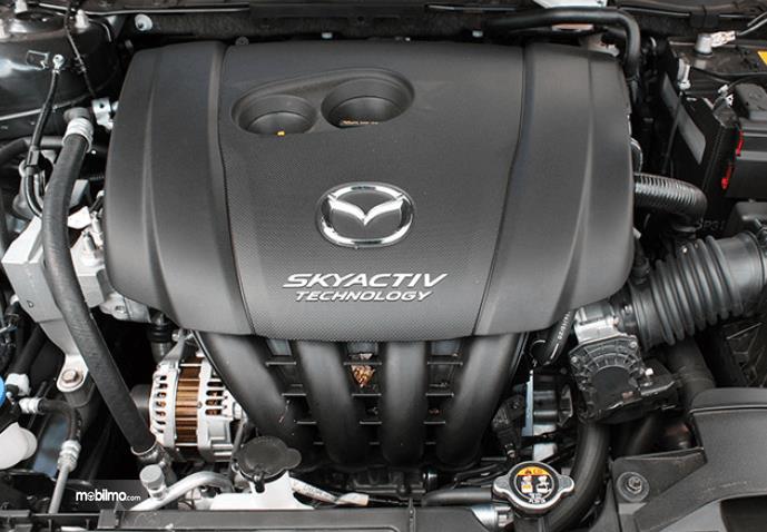 Gambar ini menunjukkan mesin pada mobil Mazda CX-3 2016 dengan tulisan Scyactive teknologi