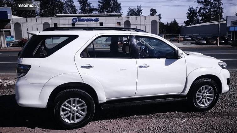 Gambar ini menunjukkan mobil Toyota Fortuner 2014 tampak samping warna putih