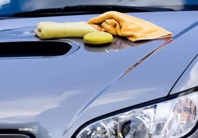 Gambar ini menunjukkan beberapa kain pembersih di atas kap mesin mobil
