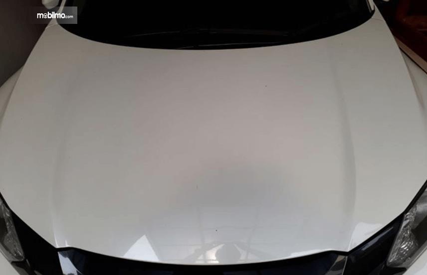 Gambar ini menunjukkan kap mesin mobil dengan warna putih