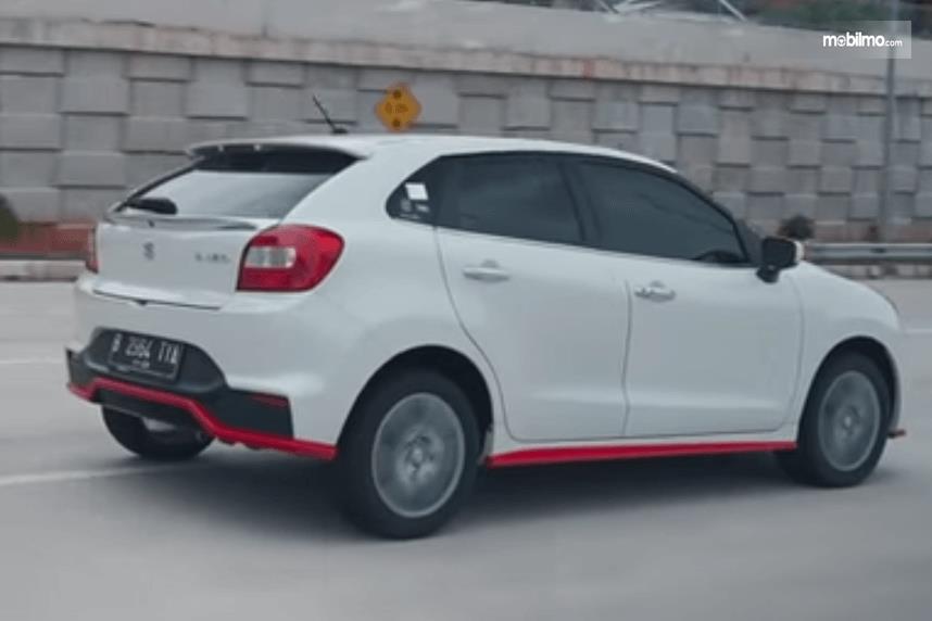 Gambar ini menunjukkan bagian belakang dan samping kanan Suzuki Baleno Hatchback AT 2018