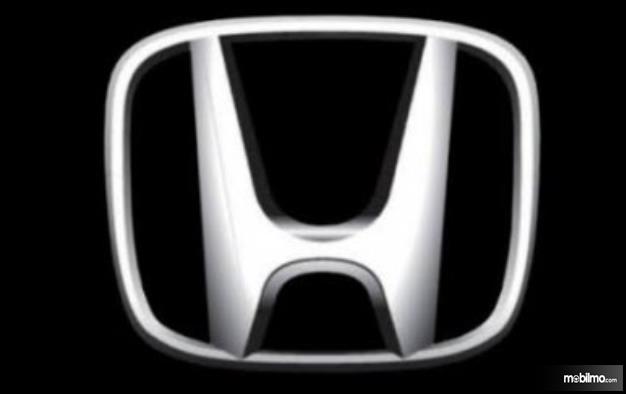 Gambar ini menunjukkan logo Honda warna chrome dengan background hitam