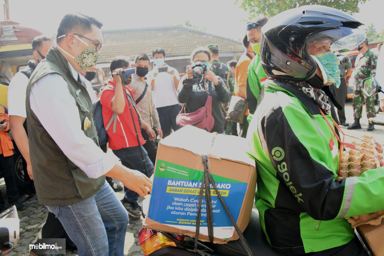 Foto menunjukkan Gubernur Jawa Barat Ridwan Kamil memanfaatkan jasa OJOL untuk salurkan bantuan COVID-19
