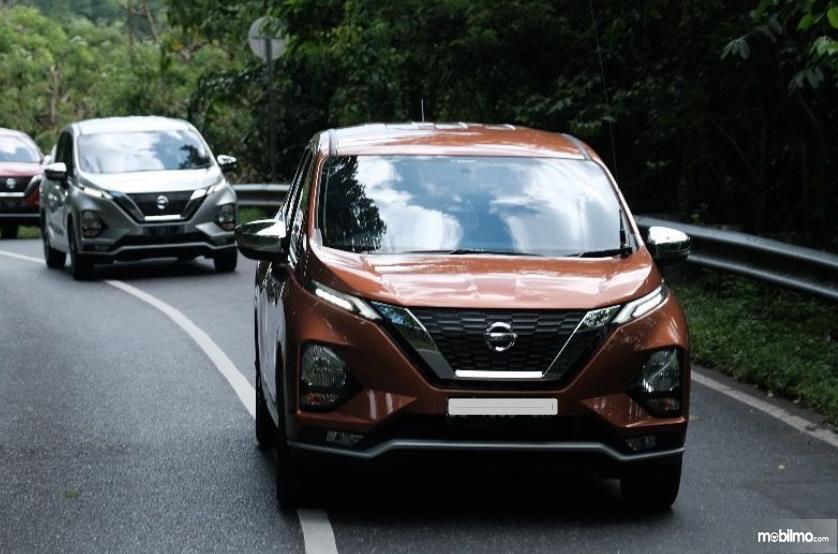 Gambar ini menunjukkan Nissan Livina melaju di jalan tampak depan
