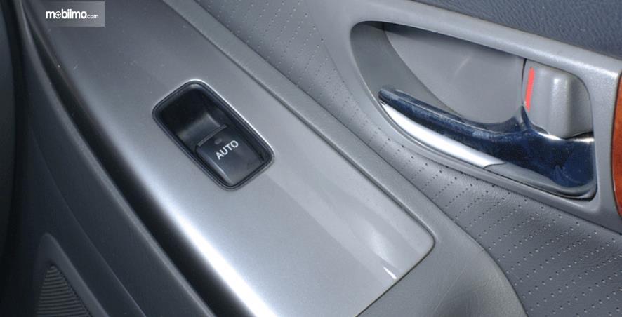 Gambar ini menunjukkan saklar power window pada pintu belakang mobil