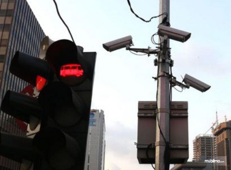 Gambar ini menunjukkan lampu lalu lintas dan beberapa CCTV di tiang